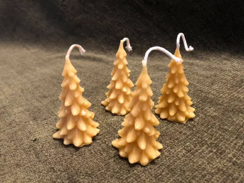 Four small beeswax candles shaped like fir trees